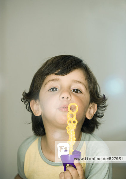 Boy playing  blowing soap bubbles