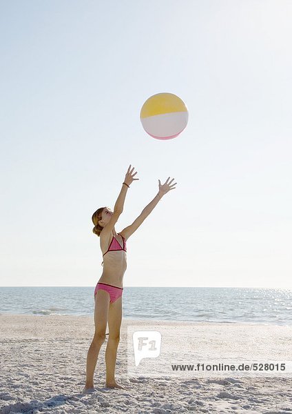 Mädchen fangen Strandball am Strand