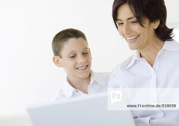 Boy and grandmother using laptop