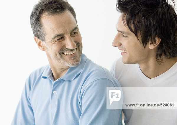 Young man and mature man smiling at each other