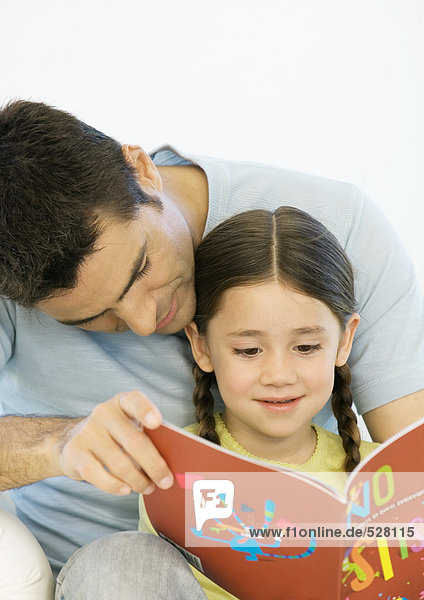 Vater und Tochter lesen gemeinsam Buch