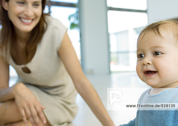 Frau lächelt und beobachtet Baby