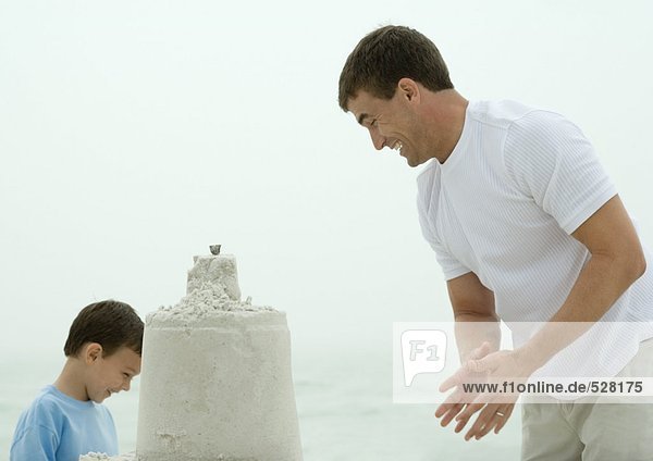 Man and son building sand castle
