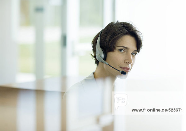 Woman wearing headset  reflection in foreground