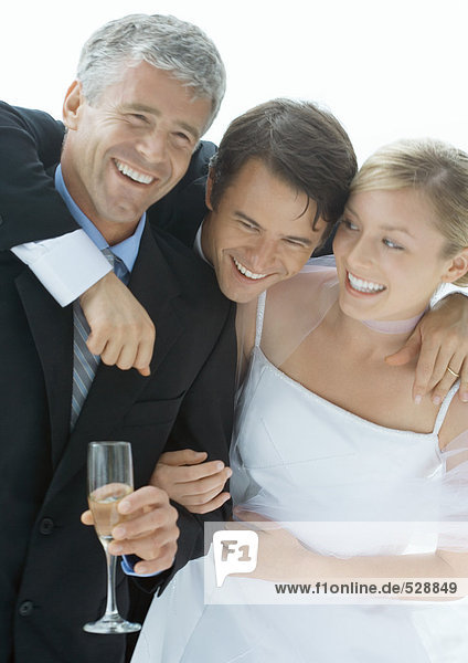 Bride and groom with father  laughing