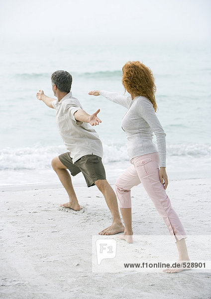 Erwachsenes Paar beim Tai Chi am Strand