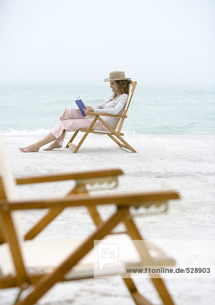 Frau am Strand sitzend im Strandkorb