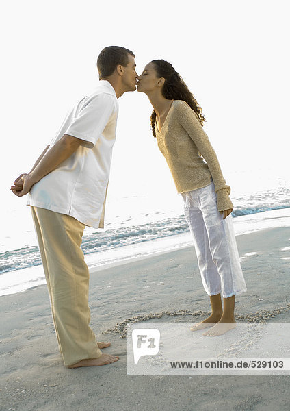 Frisch verheiratet  Frau steht im Herzen in Sand gezeichnet  lehnt sich nach vorne zu küssen Ehemann