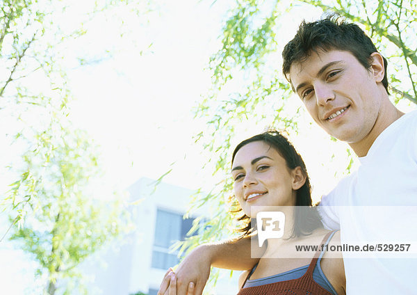 Junges Paar im Freien  lächelnd vor der Kamera