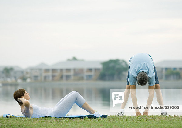 Couple working out by edge of water