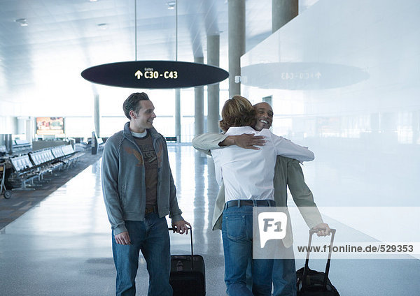 Mann und Frau umarmen sich am Flughafen