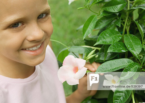 Girl next to mandevilla plant