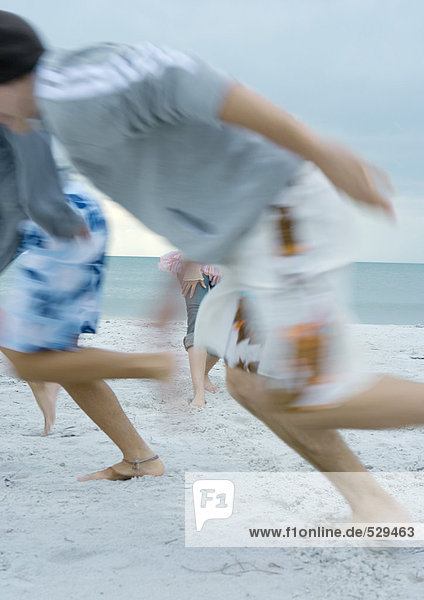 Junge Männer  die am Strand rennen