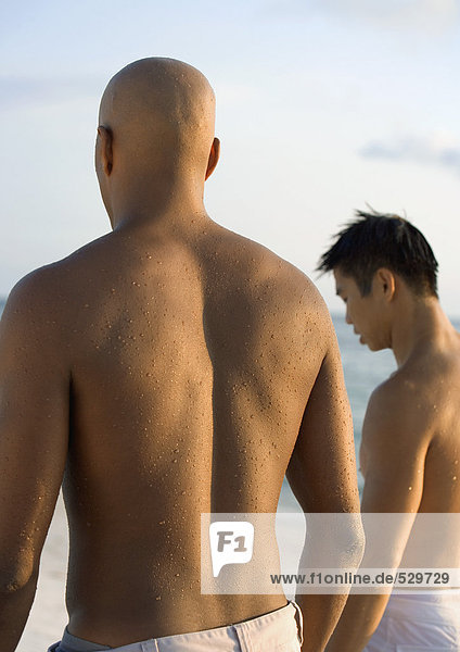 Zwei Männer stehen am Strand