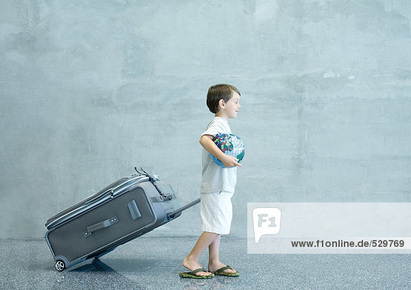 Junge mit Koffer und Globus