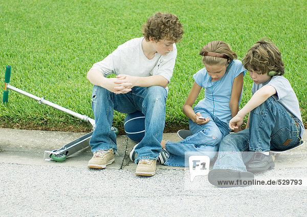 Suburan children sitting on curb