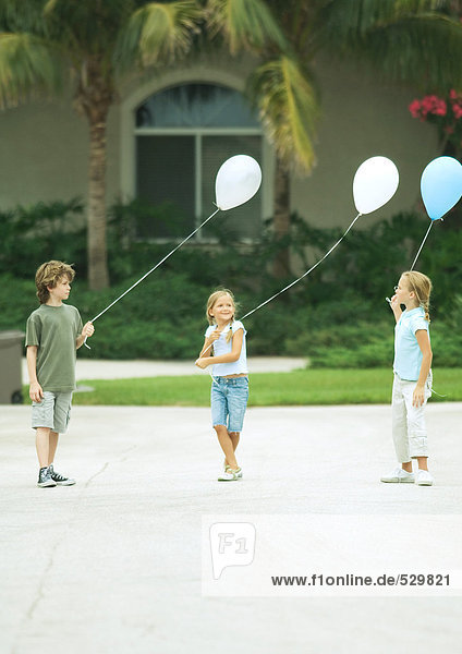 Vorstadtkinder mit Luftballons