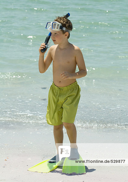 Junge mit Tauchausrüstung am Strand