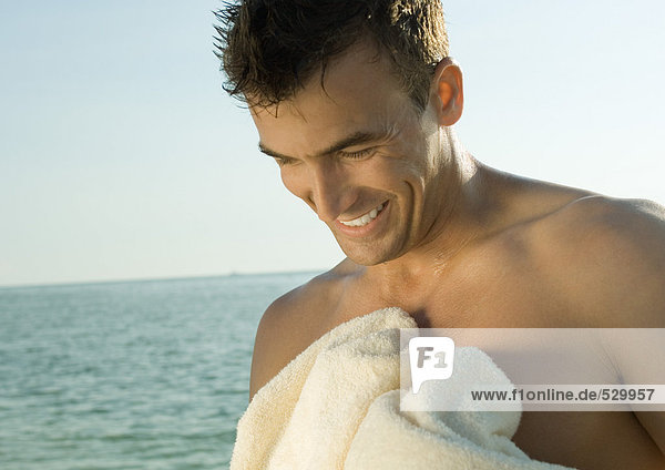 Mann mit Handtuch  Meer im Hintergrund