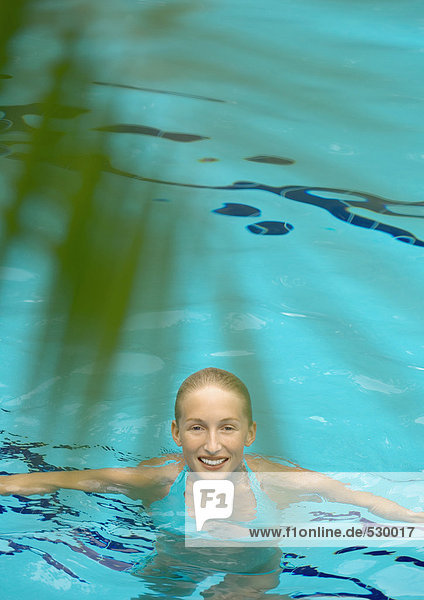 Frau im Pool  lächelnd vor der Kamera