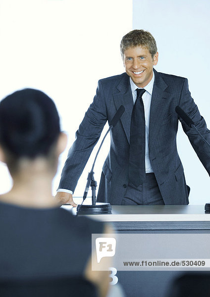Businessman standing next to microphone in seminar