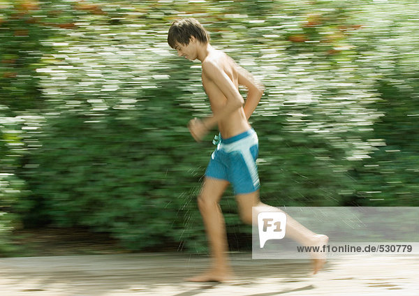 Boy in swimming trunks running