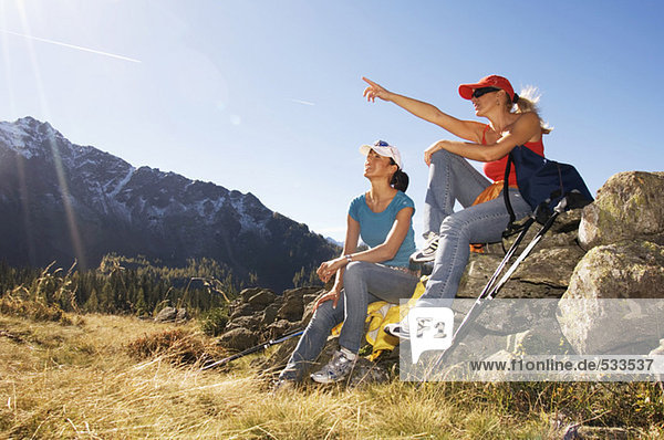 Two women in mountain  sitting on rock
