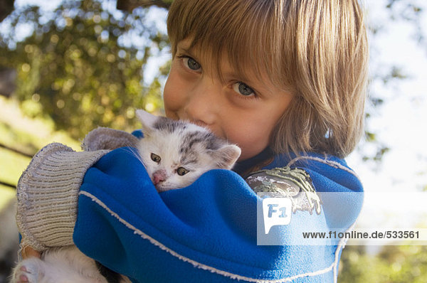 Boy (4-5) holding kitten  portrait