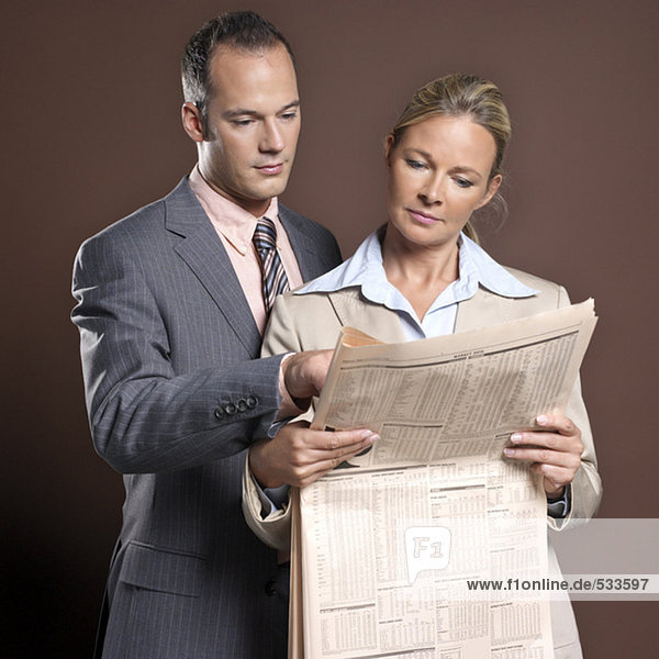 Geschäftsmann und Geschäftsfrau mit Zeitung
