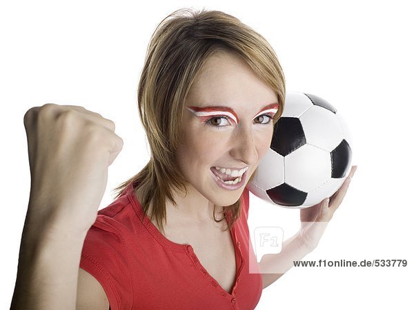Frau mit österreichischer Flagge auf Augenbrauen  die Fußball halten