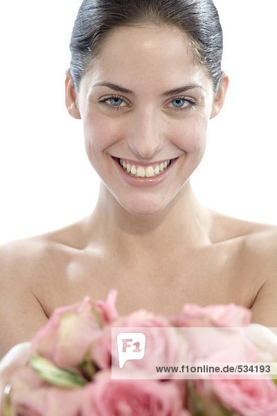 Junge Frau mit Rosenblüten  lächelnd  Portrait