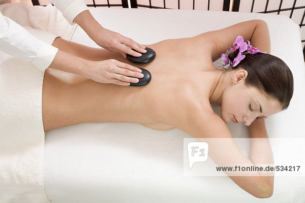 Young woman receiving hot stone massage  elevated view