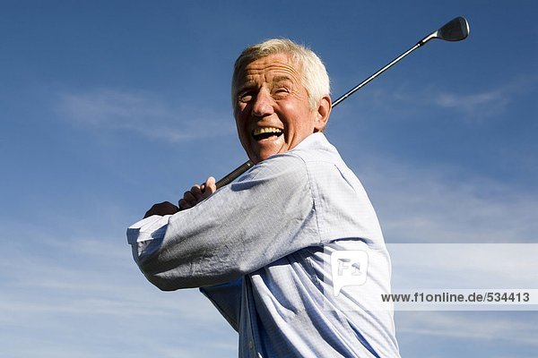Älterer erwachsener Mann mit Golfschläger