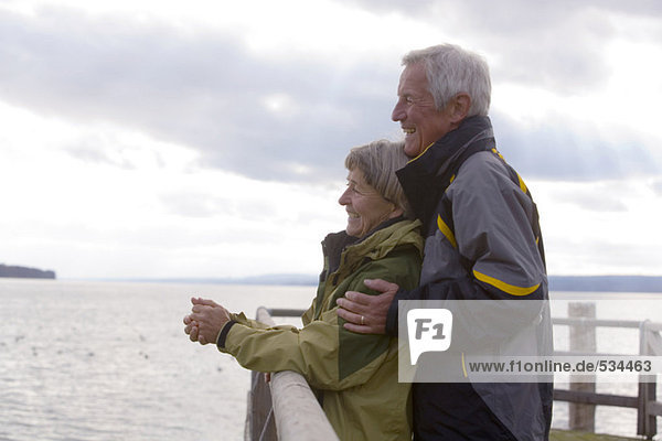 Senior couple standing on jetty  side view