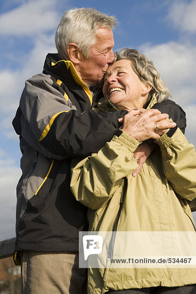 Senior Paar  Mann küssend Frau  lächelnd