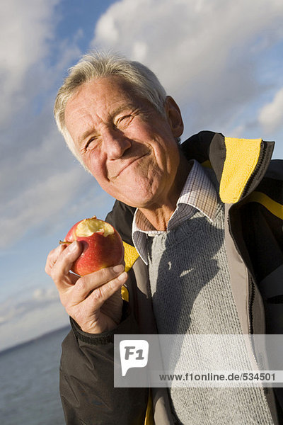 Senior erwachsener Mann beim Apfelessen