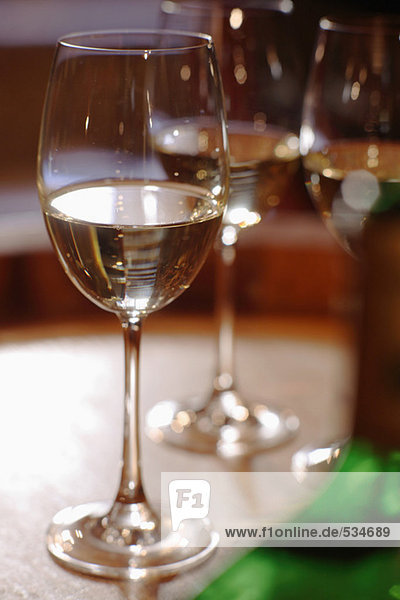 Weißweinflasche und Gläser auf Weinfass  Nahaufnahme