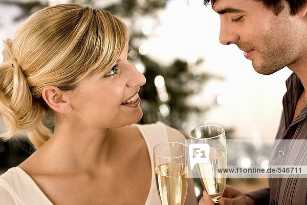 Man and woman clinking champagne glasses