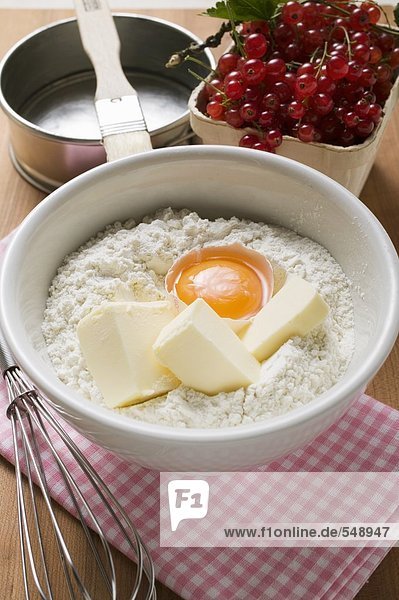 Mehl  Butter  Ei in Schüssel  Johannisbeeren und Backform