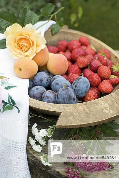 Pflaumen  Erdbeeren und Aprikosen in Holzschale