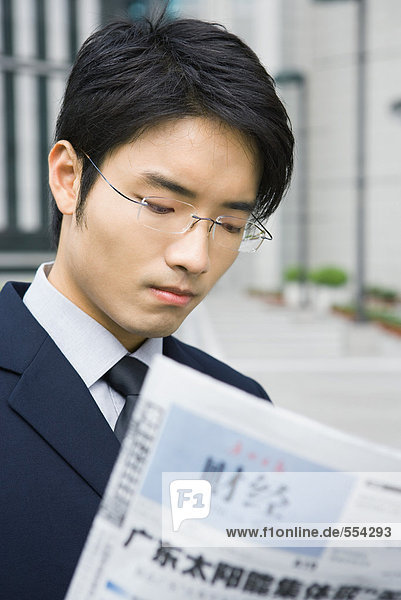Geschäftsmann liest chinesische Zeitung
