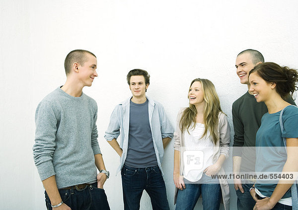 Group of young adult and teenage friends standing together  white background