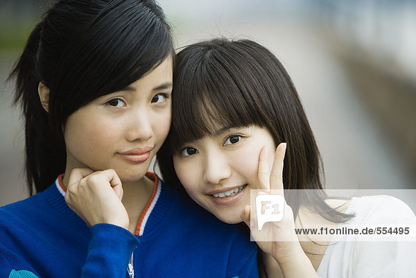 Zwei junge erwachsene Freundinnen  eine macht ein V -Zeichen mit den Fingern.