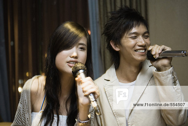 Young couple singing karaoke