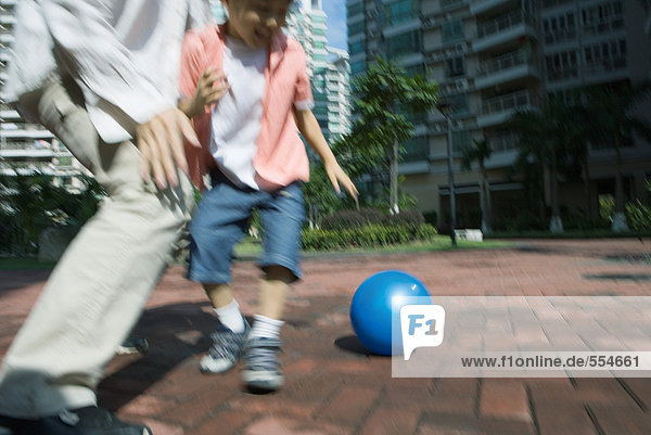 Father and son playing ball  blurred motion