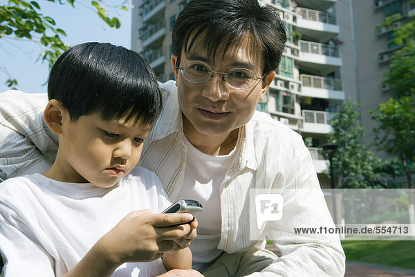 Boy and father  boy using cell phone