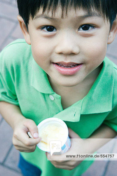Boy holding sweet snack  smiling at camera