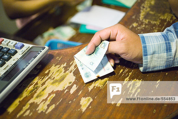 Kunde hält Banknote zum Bezahlen bereit  Ausschnittansicht