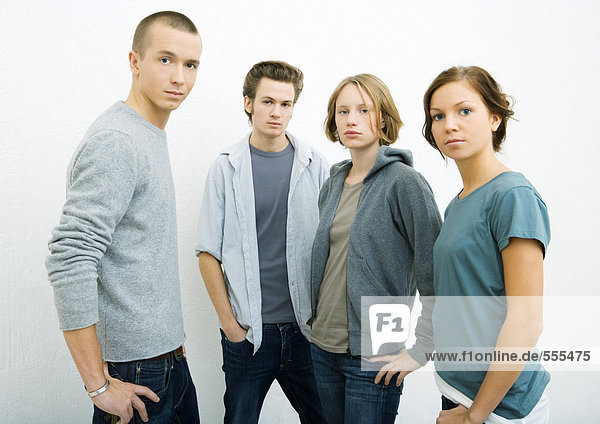 Group of young adults standing with hands on hips  looking at camera