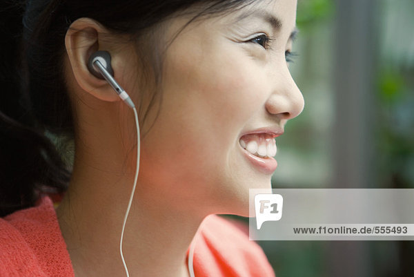 Junge Frau mit Kopfhörer  lächelnd  Nahaufnahme  Profil